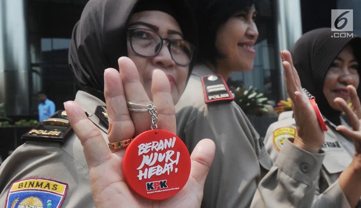 Polisi wanita (polwan) menunjukkan pin antikorupsi di depan Gedung KPK, Jakarta, Kamis (29/8/2019). Jelang HUT ke-71 Polwan RI, sejumlah polisi wanita menggelar pertemuan dengan Wakil Ketua KPK Irjen Pol (Purn) Basaria Panjaitan. (Merdeka.com/Dwi Narwoko)