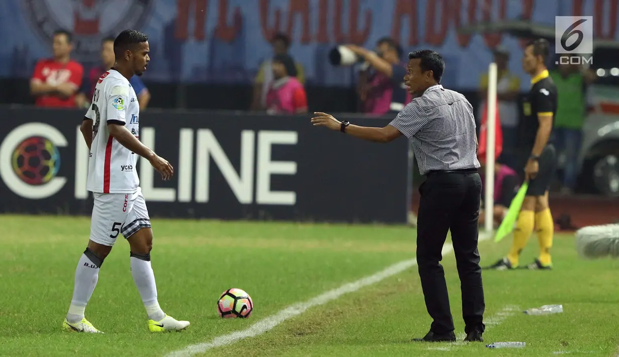 Pelatih Bali United, Widodo C Putro (kanan) memberi arahan pada pemainnya, Hasyim Kipuw dilanjutan Liga 1 Indonesia di Stadion Patriot Candrabhaga, Minggu (21/5). Laga kedua tim berakhir imbang 0-0. (Liputan6.com/Helmi Fithriansyah)