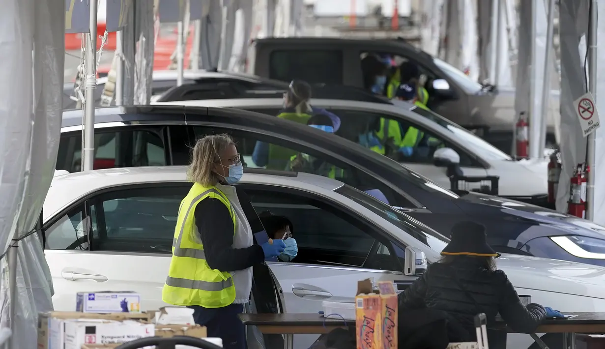 Tenaga kesehatan menunggu di mobil untuk vaksin COVID-19 di pusat vaksinasi drive-thru di City College of San Francisco di San Francisco, Senin (1/2/2021). Ketika pasokan vaksin COVID-19 meningkat, UC San Francisco memperluas upaya vaksinasi kepada mereka yang paling berisiko. (AP Photo/Jeff Chiu)