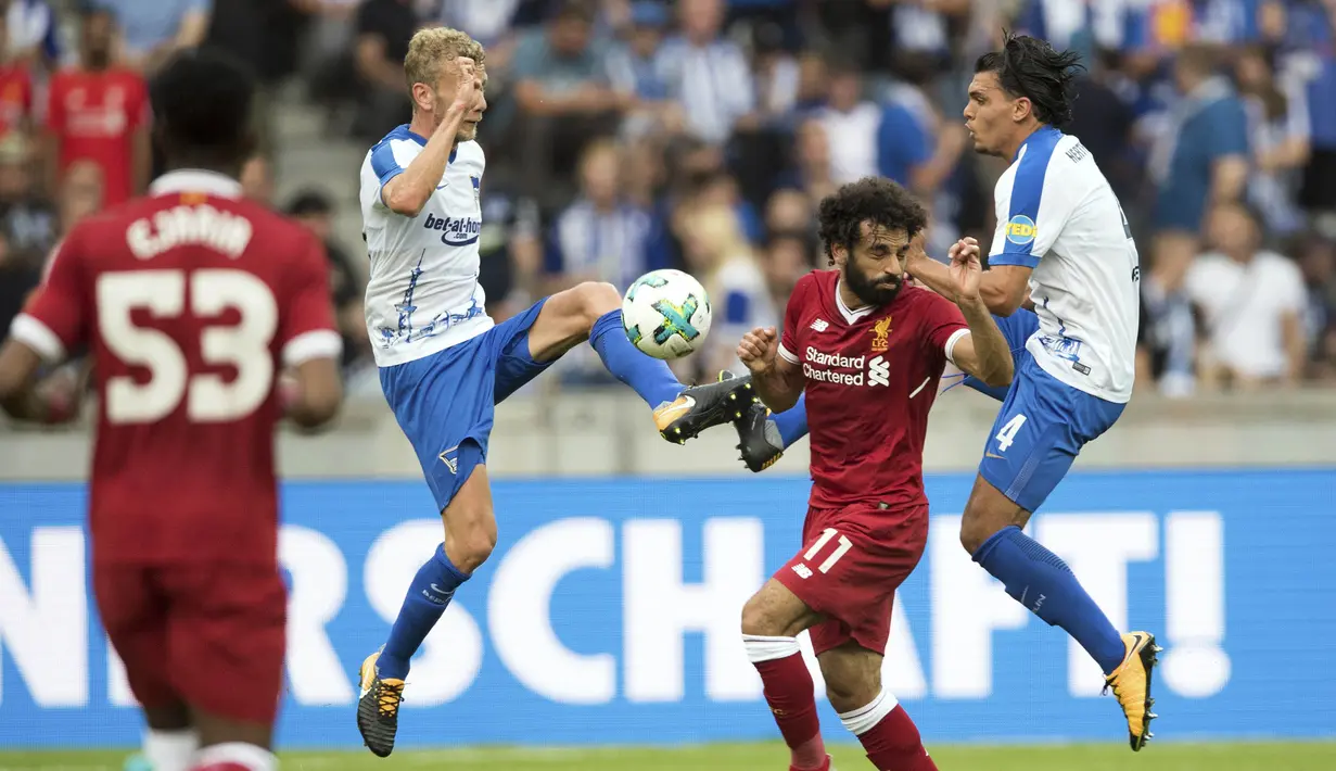 Gelandang Liverpool, Mohamed Salah, berebut bola dengan bek Hertha BSC, Fabian Lustenberger, pada laga persahabatan di Stadion Olympia, Berlin, Sabtu (29/7/2017). Hertha kalah 0-3 dari Liverpool. (AP/Soeren Stache)