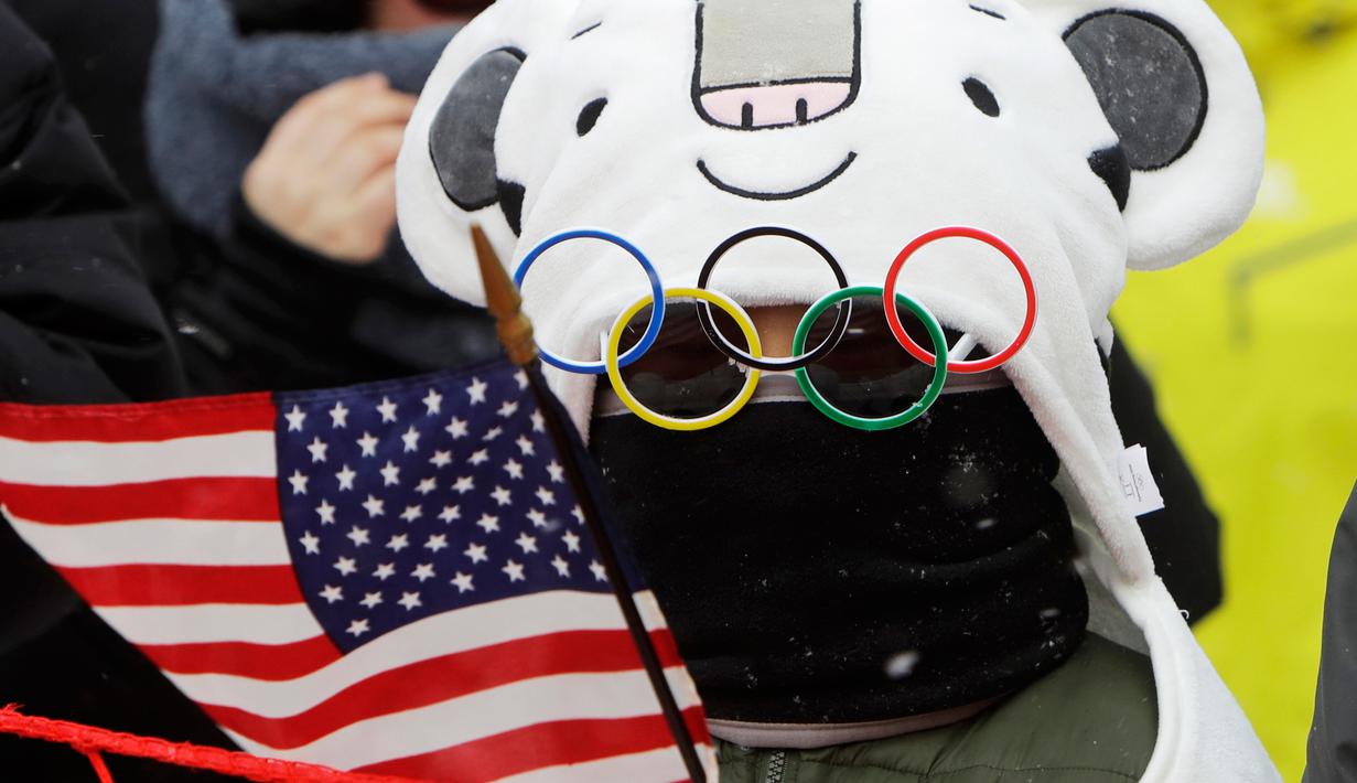 Seorang anak mengenakan kacamata unik saat menyaksikan pertandingan nomor giant slalom putri pada Olimpiade Musim Dingin 2018 di PyeongChang, Korea Selatan, Rabu (14/2). Ada 92 negara peserta yang mengikuti ajang tersebut. (AP/Michael Probst)