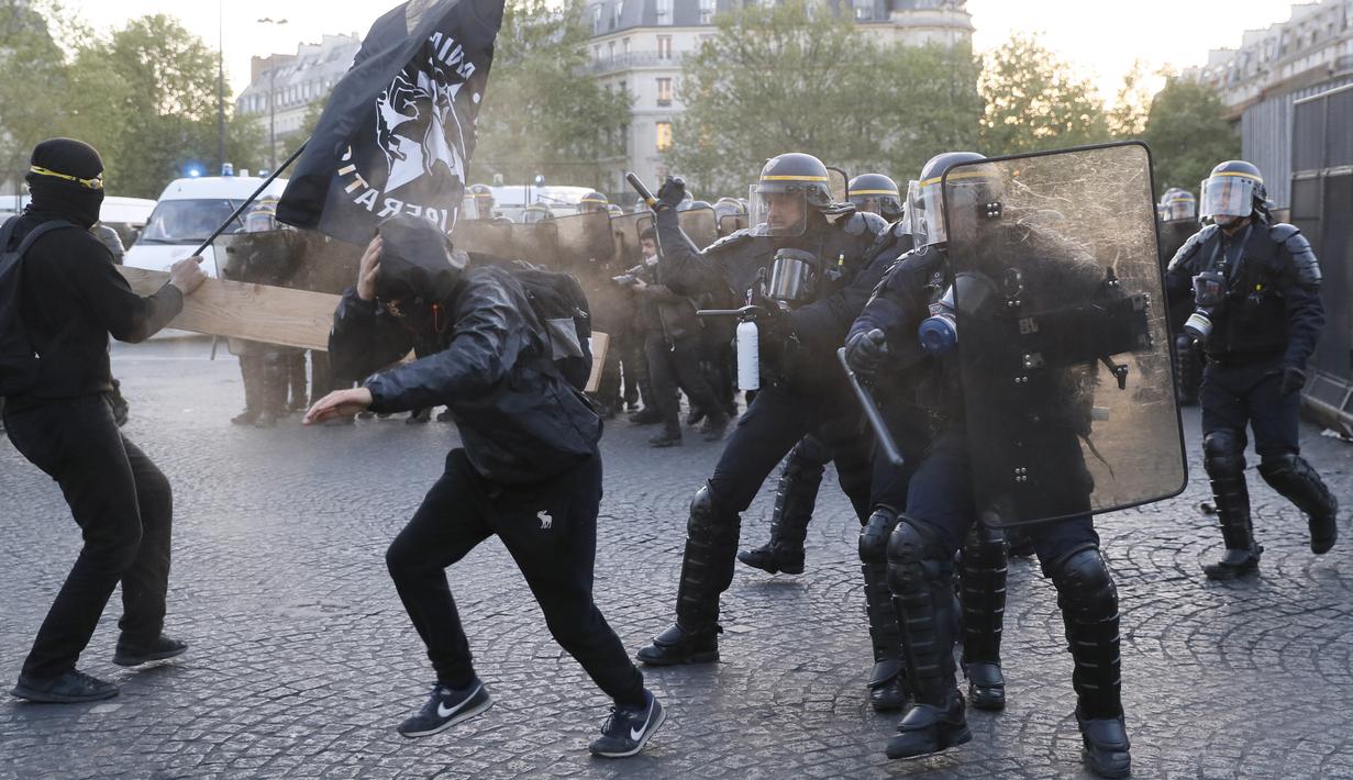 Bentrokan antara demonstran anti-fasis dengan pasukan anti-huru hara yang terjadi saat demonstran menggelar aksinya di Paris (23/4). Mereka melakukan demo untuk menentang Le Pan dan kebijakan anti imigrasinya. (AFP/Thomas Samson)