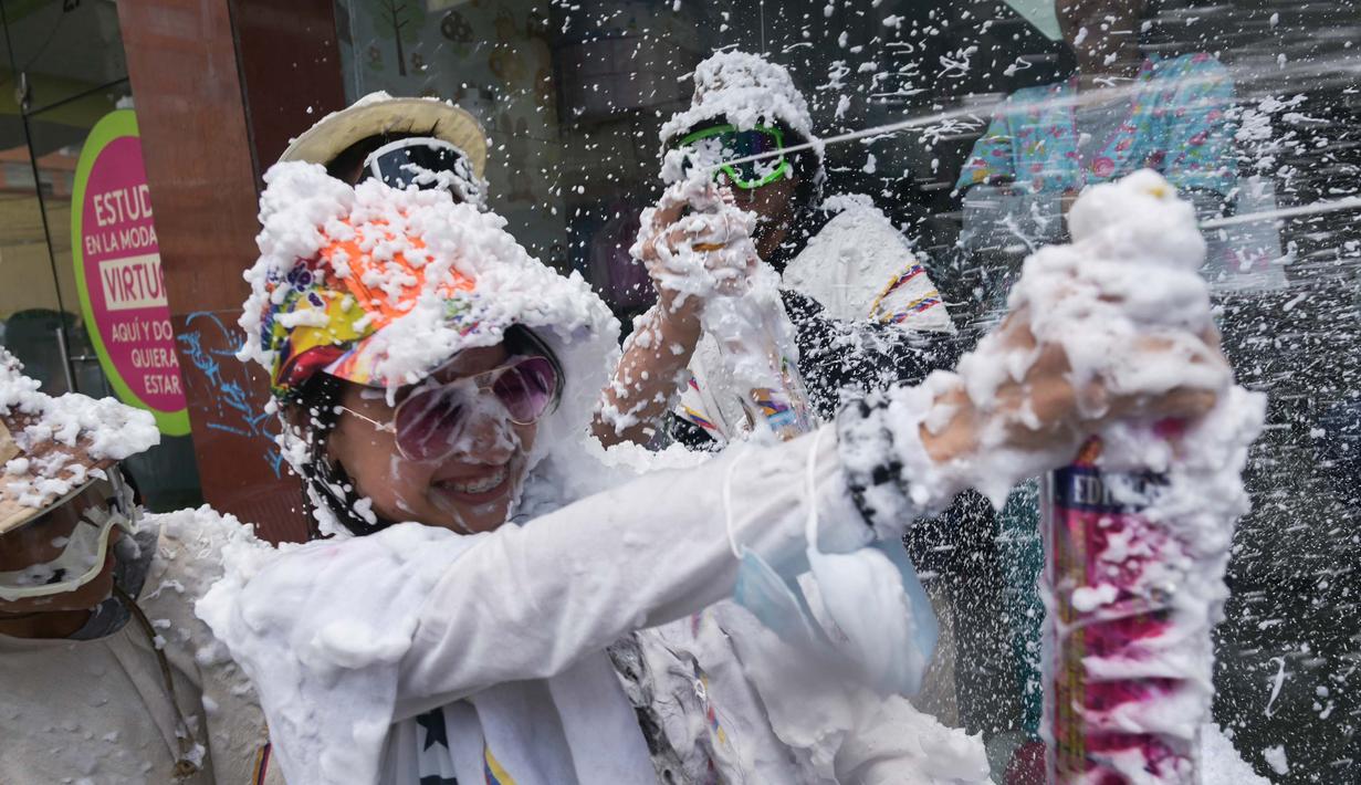 Orang-orang bermain dengan busa selama Karnaval Kulit Hitam dan Kulit Putih di Pasto, Kolombia pada tanggal 3 Januari 2024. (JOAQUIN SARMIENTO/AFP)