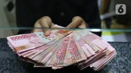 Teller menunjukkan uang rupiah di money changer, Jakarta, Rabu (9/9/2020). US$ 1 dibanderol Rp 14.780/US$ di pasar spot. Rupiah melemah 0,14% dibandingkan dengan penutupan perdagangan kemarin. (Liputan6.com/Angga Yuniar)