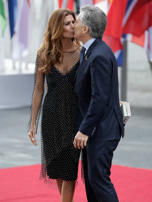 Presiden Argentinia Mauricio Macri mencium istrinya Juliana Awada saat mereka tiba menghadiri KTT G20 di aula Elbphilharmonie di Hamburg, Jerman, (7/7). Sejumlah pemimpin negara berkumpul dalam KTT G20 pada 7-8 Juli 2017. (AP Photo/Michael Sohn)