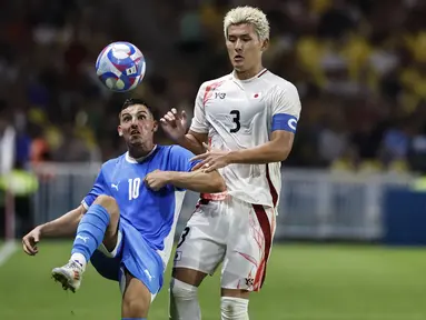 Gelandang Isrel Oscar Gloukh berebut bola dengan bek Jepang Ryuya Nishio pada matchday terakhir Grup D sepak bola Olimpiade Paris 2024 di stadion stade de la Beaujoire, Rabu (31/7/2024). (AP Photo/Jeremias Gonzalez)