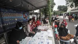 Warga antre untuk menerima hidangan berbuka puasa atau takjil gratis di Cempaka Putih, Jakarta, Selasa (19/4/2022). Pembagian takjil gratis yang telah berlangsung sejak pandemi Covid-19 ini disambut antusias warga, baik anak-anak hingga orang dewasa. (merdeka.com/Iqbal S. Nugroho)