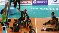 Tim voli duduk putra Iraq menghadang smash pemain Indonesia saat berhadapan pada pertandingan Asian Para Games di GBK, Jakarta, Senin (8/10). Indonesia kalah dari Iraq dengan skor 25-11, 25-10, dan 25-10. (Merdeka.com/Imam Buhori)