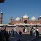 Umat Islam Pakistan setelah selesai melaksanakan salat  Idul Fitri di Masjid Badshahi di Lahore pada 24 Mei 2020. Umat Muslim di seluruh dunia mulai menandai Idul Fitri yang suram di tengah pembatasan akibat corona Covid-19 . (Photo by Arif ALI / AFP)