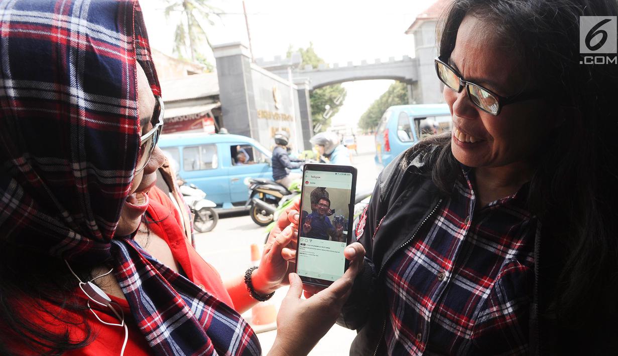 Pendukung menunjukkan foto Basuki Tjahaja Purnama atau Ahok di Mako Brimob, Kelapa Dua, Depok, Jawa Barat, Kamis (24/1). Menurut staf Ahok, Ima Mahdiah, mantan Gubernur DKI Jakarta itu sedang berkumpul bersama keluarga. (Liputan6.com/Herman Zakharia)