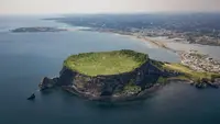 Pemandangan udara Seongsan Ilchulbong, atau 'Puncak Matahari Terbit', formasi batuan vulkanik di pulau Jeju, Korea Selatan (10/5/2019). Pulau Jeju adalah pulau terbesar di Korea dan terletak di sebelah selatan Semenanjung Korea. (AFP Photo/Ed Jones)