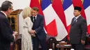 Sebelum kedua kepala negara tersebut melakukan pertemuan empat mata, istri Presiden Prancis Emmanuel Macron, Brigitte Macron, terlihat berpamitan untuk meninggalkan ruangan. (Ludovic MARIN/AFP)