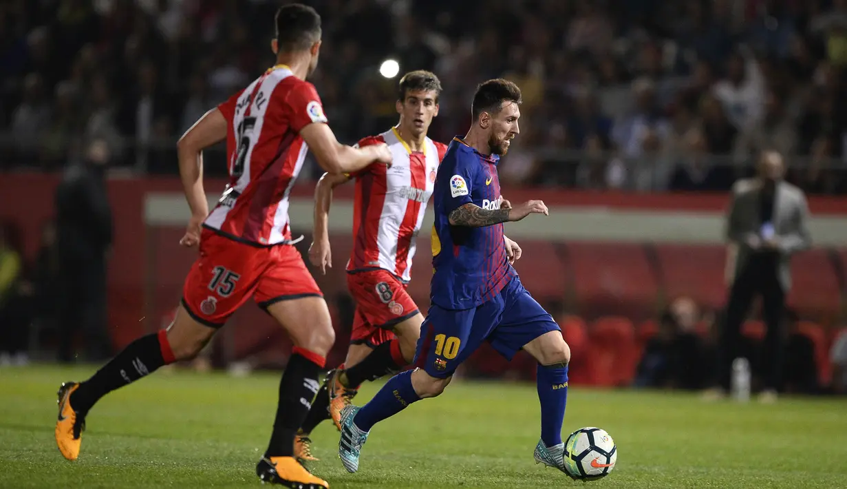 Bintang Barcelona, Lionel Messi, berusaha melewati bek Girona, Juanpe Ramirez, pada laga La Liga Spanyol di Stadion Montilivi, Girona, Sabtu (23/9/2017). Girona kalah 0-3 dari Barcelona. (AFP/Josep Lago)