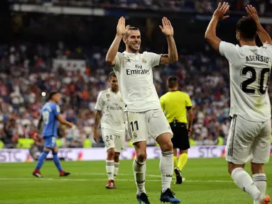 Gelandang Real Madrid, Gareth Bale (kiri) berselebrasi dengan rekannya Marco Asensio setelah mencetak gol ke gawang Getafe pada lanjutan La Liga Spanyol di stadion Santiago Bernabeu, Madrid, (19/8). Madrid menang 2-0 atas Getafe. (AP Photo/Andrea Comas)