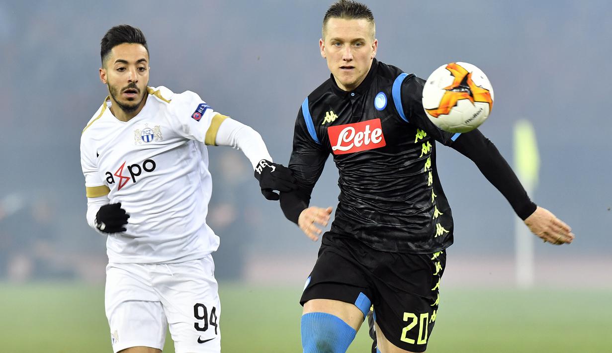 Pemain Napoli, Piotr Zielinski, berebut bola dengan pemain FC Zurich, Salim Khelifi, pada laga Liga Europa di Stadion Letzigrund, Kamis (14/2). Napoli menang 3-1 atas FC Zurich. (AP/Walter Bieri)
