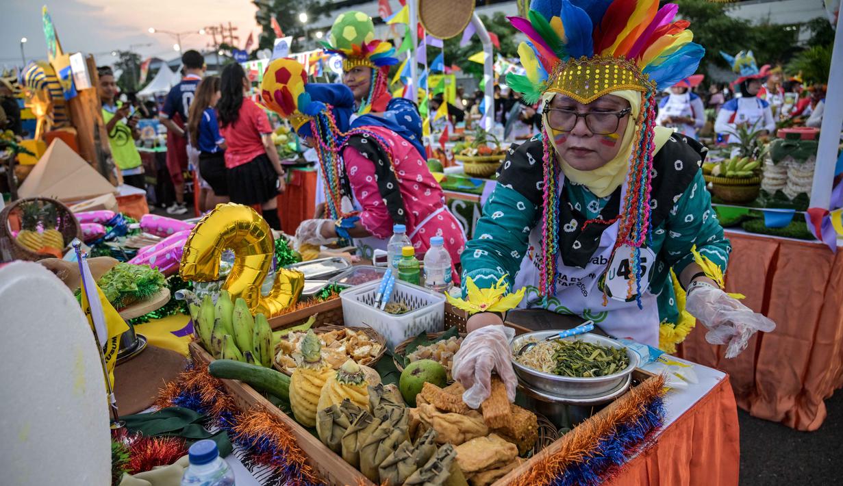 Berbagai peserta tampil kreatif dengan memadukan unsur olahraga sepak bola internasional bersama kekayaan kuliner khas Surabaya. Tampak dalam foto, para peserta yang mengenakan seragam tim sepak bola menyiapkan rujak uleg, salad gurih tradisional Indonesia yang berisi moncong sapi dan sayuran, dalam Festival Rujak Uleg 2026 di Surabaya, Jawa Timur, Sabtu 9 Mei 2026. (JUNI KRISWANTO/AFP)