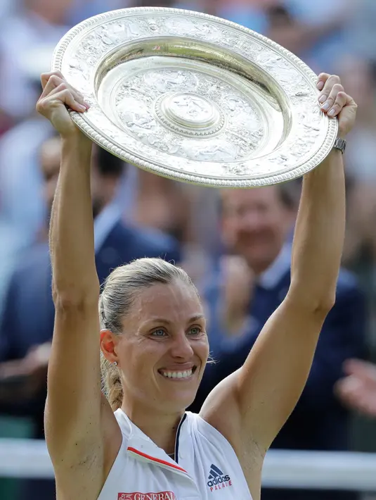 Petenis Jerman, Angelique Kerber tersenyum sambil mengangkat trofi usai mengalahkan petenis AS, Serena Williams pada final tunggal putri kejuaraan Tenis Wimbledon 2018 di London, (14/7). Kerber menang atas Williams 6-3,6-3. (AP Photo/Ben Curtis)