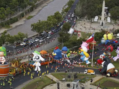 Parade balon karakter kartun meramaikan jalanan kota Santiago di Chile, (13/12). Kegiatan ini untuk menyambut Natal yang akan jatuh sebentar lagi. (REUTERS/Pablo Sanhueza)