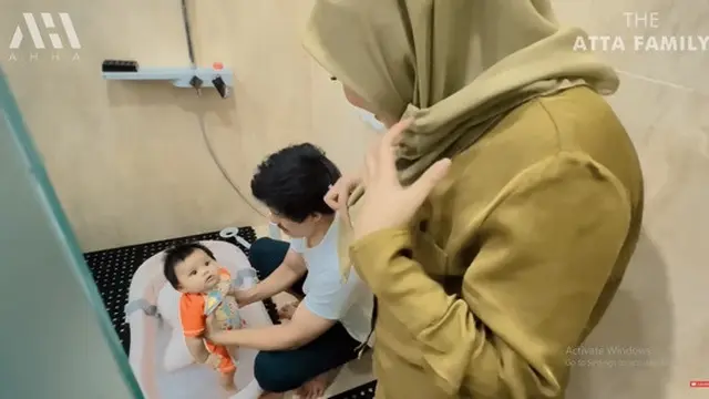 Atta Halilitar dibantu Aurel Hermansyah memandikan Ameena. (Foto: YouTube/AH)