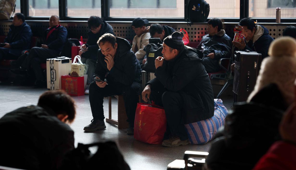 Gelombang mudik tahunan terbesar di dunia ini resmi dimulai sejak Senin (2/2/2026) atau tepat 15 hari menjelang perayaan Tahun Baru Imlek atau Festival Musim Semi 2026. Tampak dalam foto, para penumpang duduk di samping barang bawaan mereka sambil menunggu di stasiun kereta api dalam perjalanan pulang selama liburan Tahun Baru Imlek di Beijing, China, Selasa 10 Februari 2026. (AP Photo/Vincent Thian)