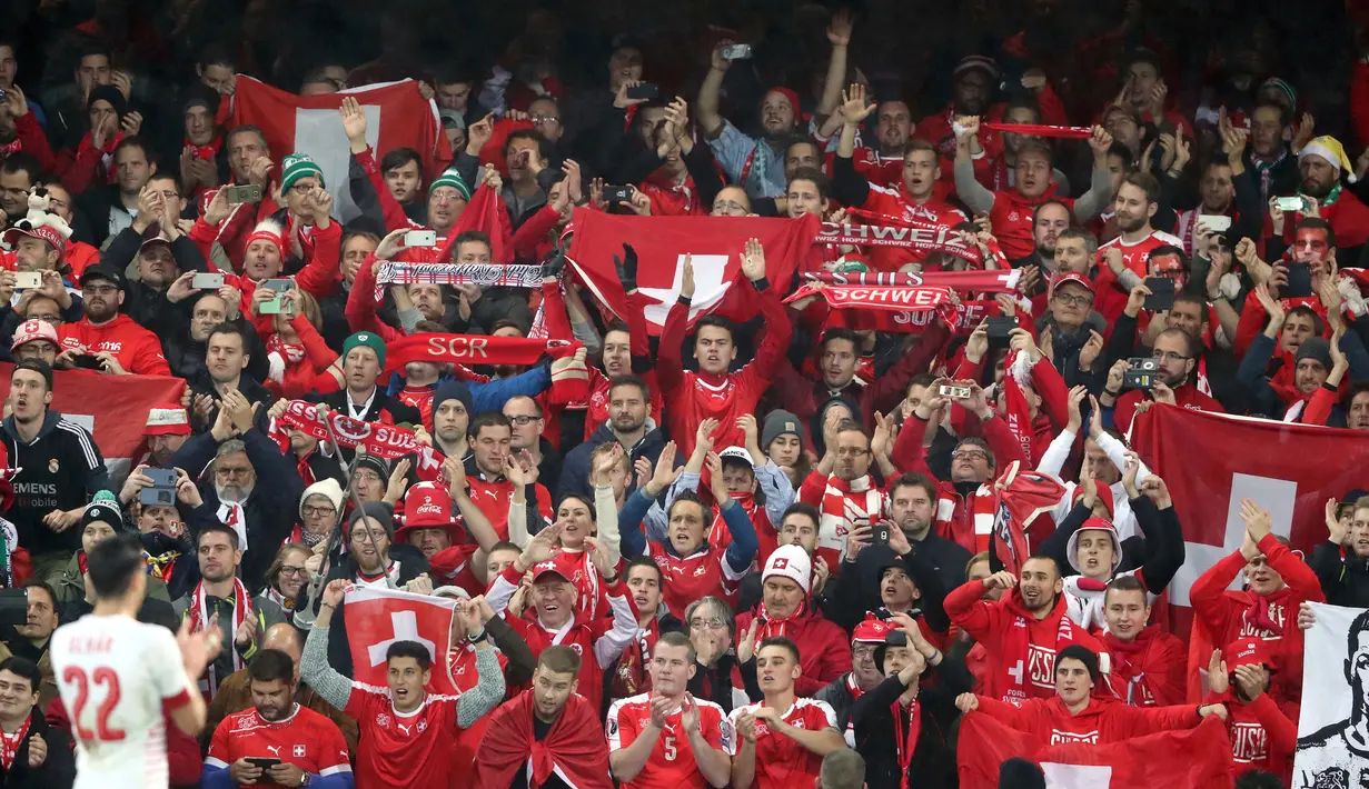 Suporter timnas Swiss merayakan kemenangan tim kesayangan mereka atas Irlandia Utara pada leg pertama playoff Piala Dunia 2018 di Windsor Park, Jumat (10/11). Bermain di kandang lawan, Swiss meraih kemenangan tipis 1-0. (AP/Peter Morrison)