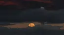 Fenomena strawberry moon atau Bulan Stroberi terakhir kali muncul pada 2006 dan akan datang kembali pada tahun 2043. Tampak dalam foto, bulan purnama yang dikenal sebagai 'Bulan Stroberi' muncul di atas Pantai Bondi di Sydney, Australia pada 11 Juni 2025. (SAEED KHAN/AFP)