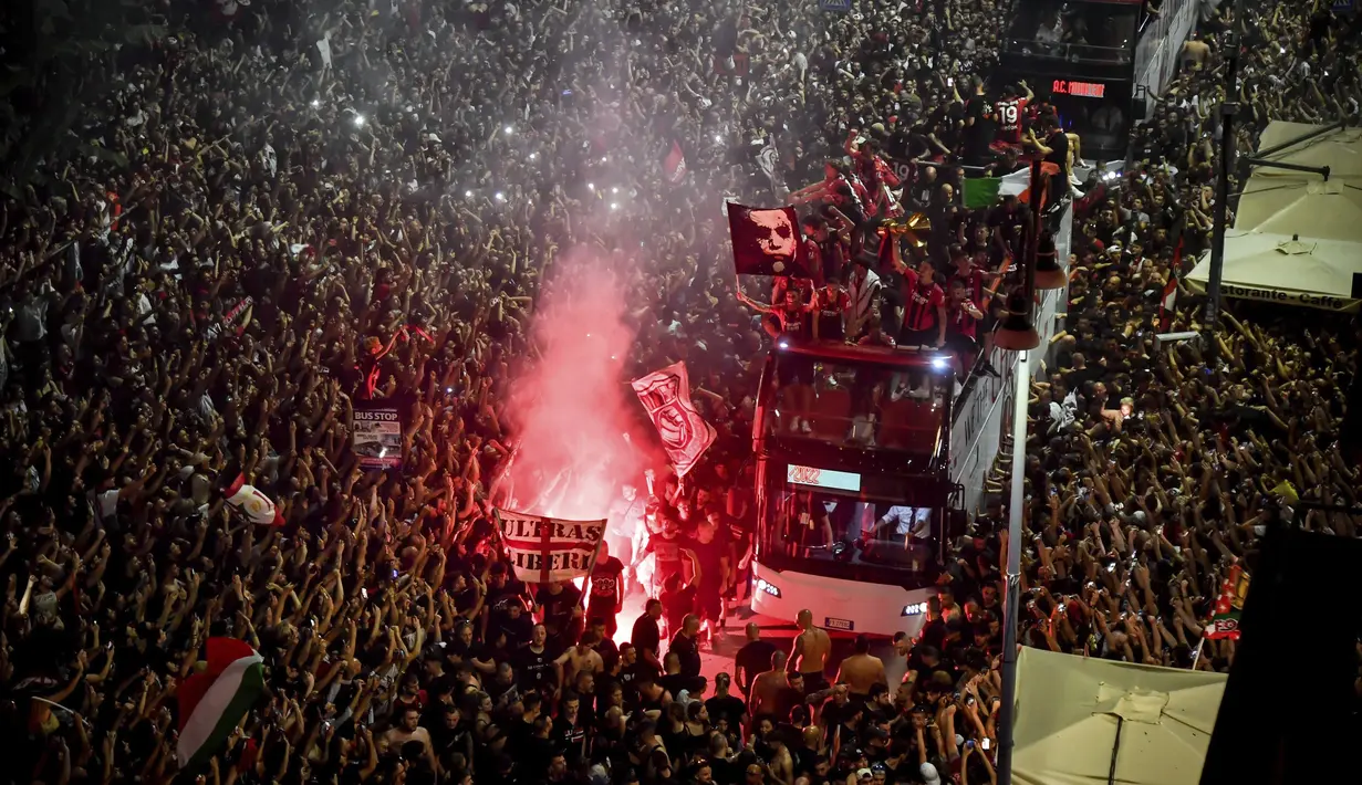 Ribuan penggemar bersorak saat bus yang membawa para pemain tim sepak bola AC Milan melakukan parade kemenangan Liga Italia di depan Katedral Gotik Milan, Milan, Italia, 23 Mei 2022. (LaPresse via AP)