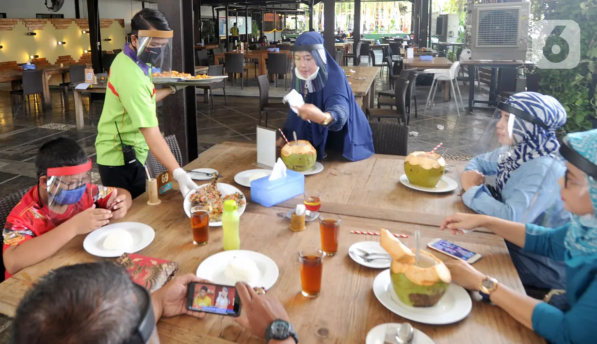 Pelayan mengenakan pelindung wajah saat melayani pengunjung di Restoran Bandar Djakarta, Alam Sutra, Tangerang Selatan, Banten, Rabu (10/6/2020). Tangerang dan Tangerang Selatan menjalankan PSBB transisi menuju kenormalan baru dengan menerapkan protokol kesehatan COVID-19. (merdeka.com/Arie Basuki)