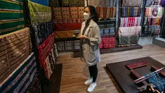 Pengunjung melihat kain tenun khas NTT di kedai Kopi Bajawa Flores NTT di Bintaro, Tangerang Selatan (20/11/2021). Kedai Kopi Bajawa kedua setelah Tebet menyajikan minuman dan makanan Bajawa yang dipadukan dengan interior Flores NTT. (Liputan6.com/Fery Pradolo)
