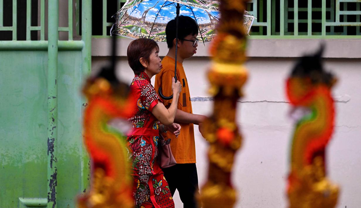 Orang-orang berjalan untuk berdoa di sebuah pura pada hari pertama Tahun Baru Imlek 2577 Kongzili di Banda Aceh, Provinsi Aceh, pada Selasa 17 Februari 2026. (CHAIDEER MAHYUDDIN/AFP)