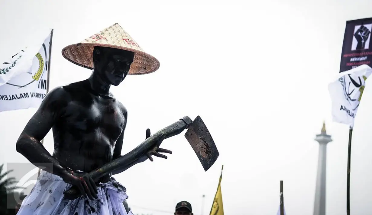 Seorang massa petani dari berbagai provinsi melakukan aksi teatrikal saat menggelar demonstrasi di kawasan Medan Merdeka, Jakarta, Selasa (27/9). Aksi menyuarakan aspirasi petani itu digelar dalam rangka Hari Tani Nasional. (Liputan6.com/Faizal Fanani)
