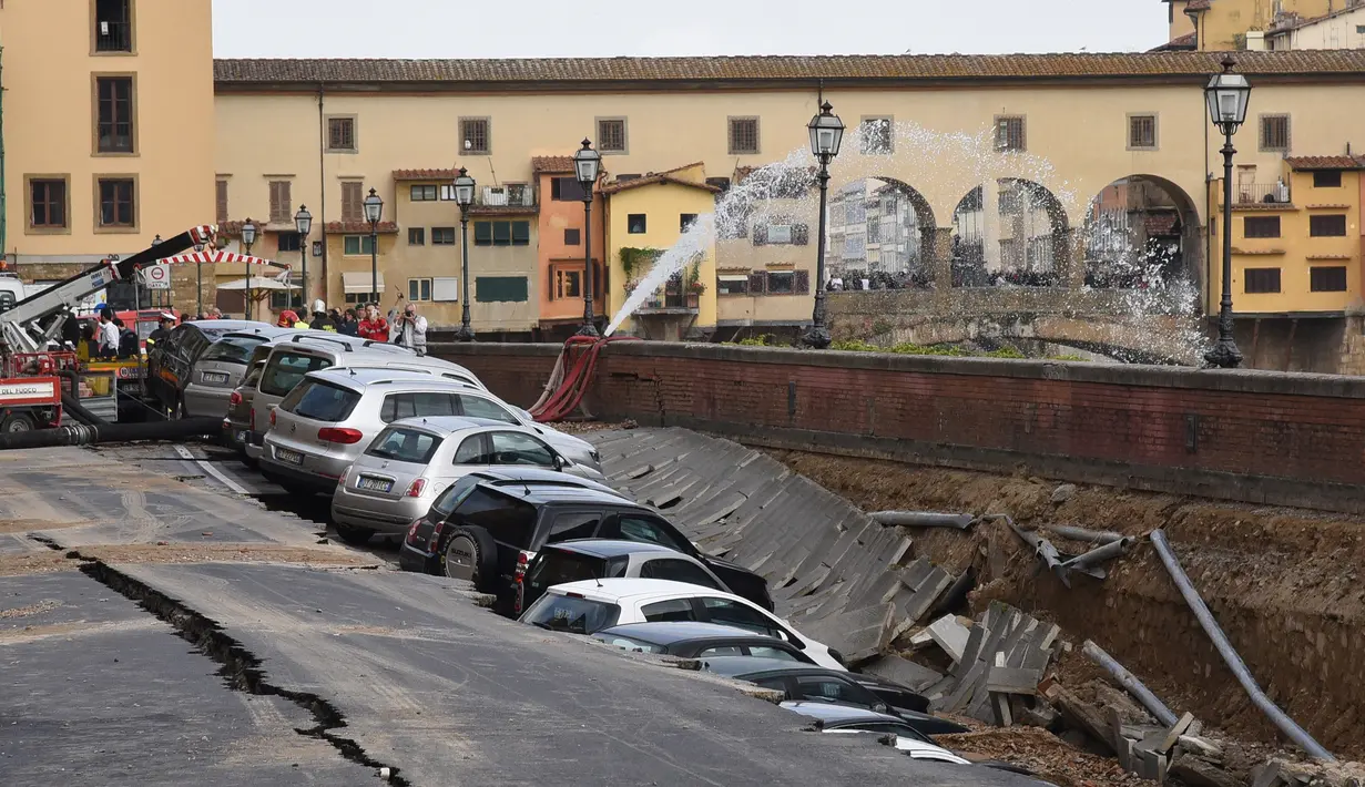 Puluhan mobil terpelosok saat parkir di pinggir sungai Arno yang tiba-tiba amblas di Lungarno Torrigiani, Florence, Italia (25/5). Menurut petugas, kejadian tersebut disebabkan oleh pecahnya pipa besar saluran air. (AFP PHOTO/CLAUDIO GIOVANNINI)