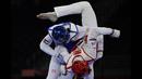 Saleh Elsharabaty dari Yordania (Biru) dan Achraf Mahboubi dari Maroko (Merah) berlomba dalam perempat final taekwondo putra -80kg Olimpiade Tokyo 2020 di Makuhari Messe Hall di Tokyo, Senin (26/7/2021). (Foto: AFP/Javier Soriano)