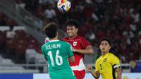 Striker Timnas Indonesia U-23, Hokky Caraka berbenturan dengan kiper Malaysia dalam laga Grup A Piala AFF U-23 2025 di Stadion Utama Gelora Bung Karno, Jakarta, Senin (21/7/2025). (Bola.com/Abdul Aziz).