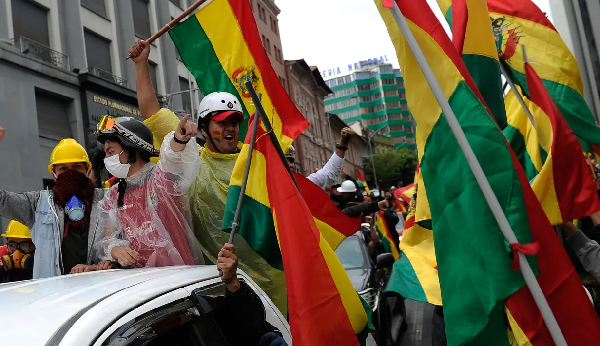 Orang-orang turun ke jalan merayakan pengunduran diri Presiden Bolivia Evo Morales di La Paz, Minggu (10/11/2019). Morales memutuskan mengundurkan diri buntut aksi protes yang dilatarbelakangi dugaan dirinya melakukan kecurangan dalam pemilu dalam beberapa pekan terakhir. (JORGE BERNAL/AFP)