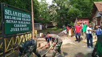 TNI bersama Tim Sar gabungan membersihkan tumpukan lumpur yang terbawa arus banjir di kawasan Situs Sunan Kalijaga di Cirebon. Foto (Liputan6.com / Panji Prayitno)
