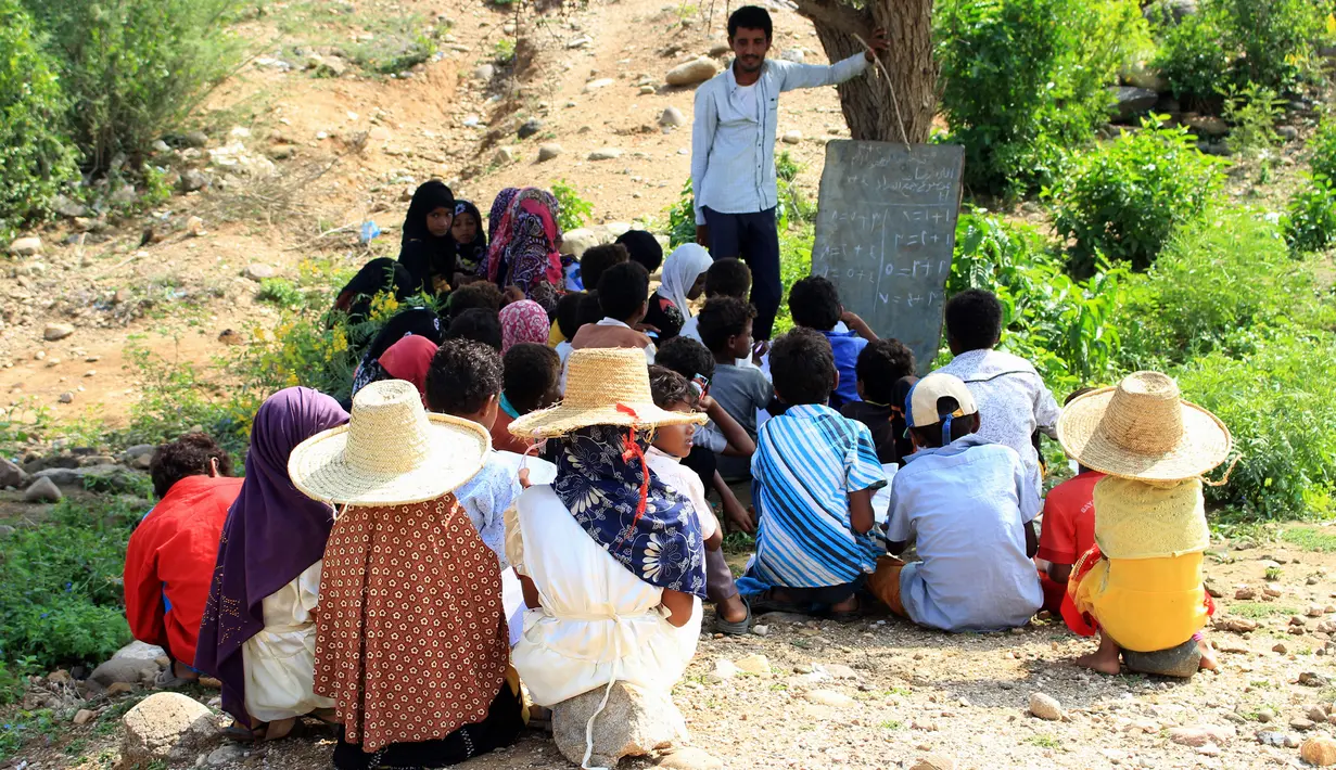 Para pelajar Yaman yang terlantar menghadiri kelas di bawah pohon sebuah lapangan terbuka, di distrik Abs utara, Yaman pada 28 Oktober 2018. UNICEF menyebut sekitar dua juta anak di Yaman putus sekolah, sejak konflik melanda pada 2015. (ESSA AHMED/AFP)