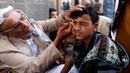 Ekspresi seorang pria saat kelopak matanya dirias dengan kohl atau celak di  Masjid Agun di kota tua ibukota Sanaa, Yama, (19/5). Pemakaian kohl atau celak ini sudah menjadi tradisi muslim Yaman pada setiap bulan Ramadan. (AFP Photo/Mohammed Huvais)