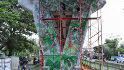 Seniman melukis mural pada dinding Jalan Layang Pesing di Jakarta Barat, Sabtu (7/12/2019). Mural pada jalan layang sepanjang 1,5 kilometer tersebut merupakan bagian dari program Pemerintah Provinsi DKI Jakarta dalam mempercantik Ibu Kota. (Liputan6.com/Johan Tallo)