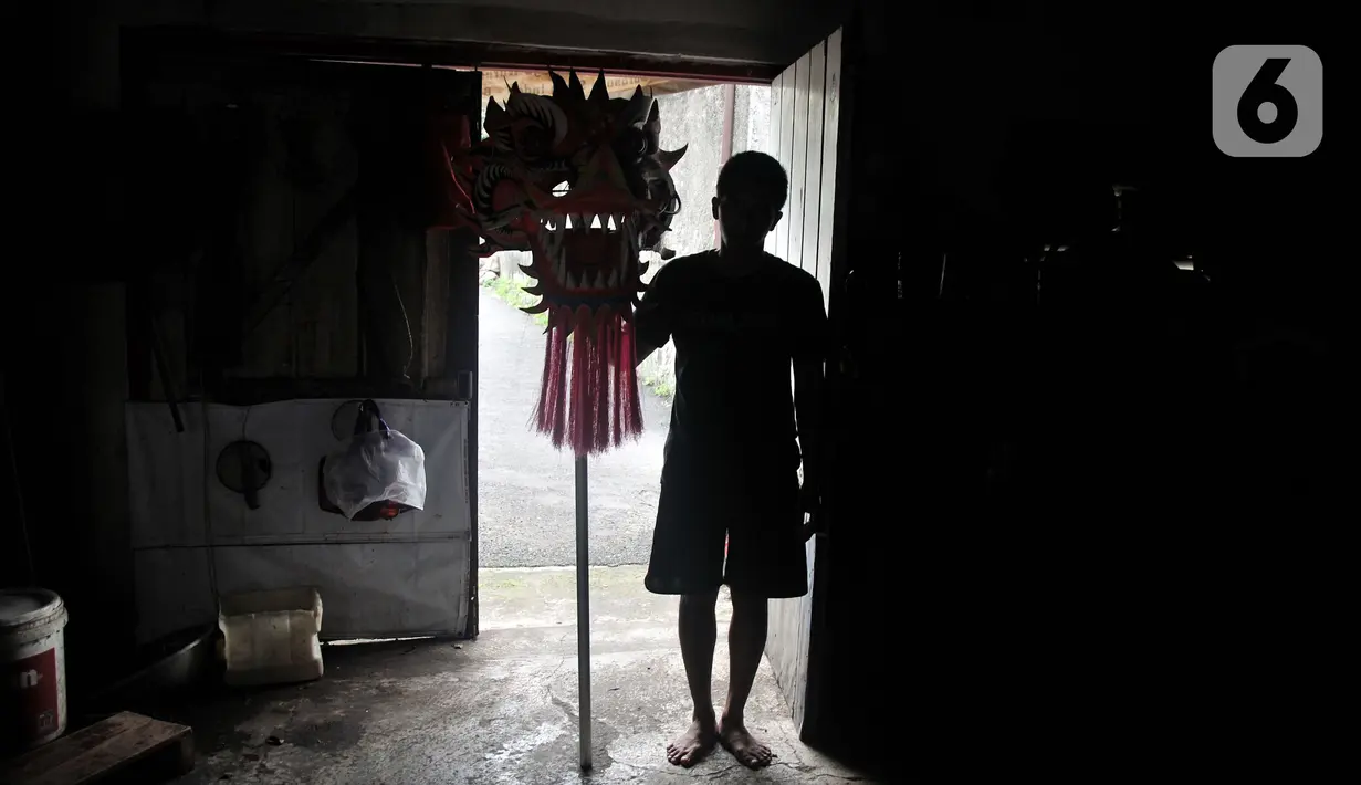 Seorang anggota Naga Merah Putih membawa kepala Liong saat akan latihan di kawasan Babakan Pasar, Bogor, Jawa Barat, Senin (17/1/2022). Latihan dilakukan untuk meningkatkan kekompakan dan kemahiran sebelum tampil dalam pementasan. (merdeka.com/Iqbal S. Nugroho)