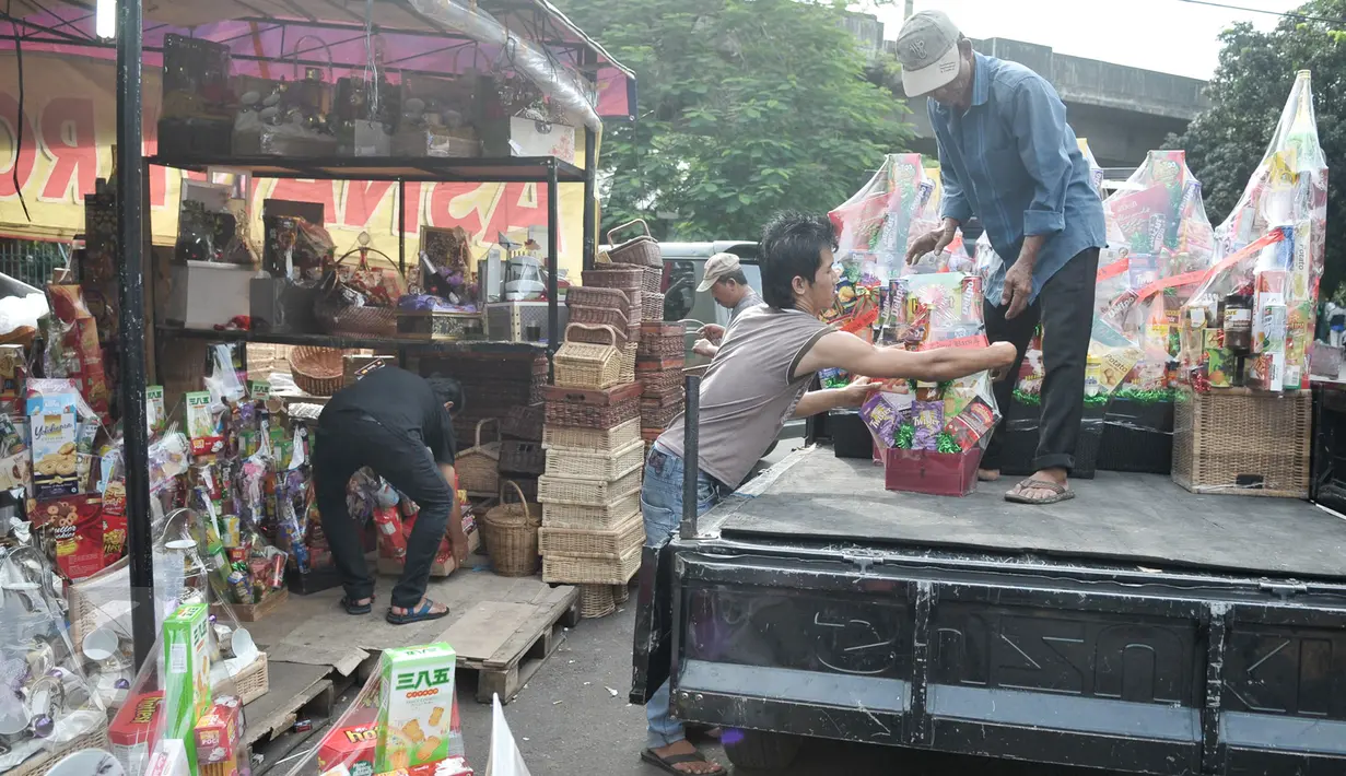 Pedagang menaikan parcel ke atas mobil di kawasan Pasar kembang, Cikini, Jakarta, Jumat (16/12). Jelang hari raya Natal, pedagang parcel di kawasan Cikini masih sepi pembeli. (Liputan6.com/Yoppy Renato)