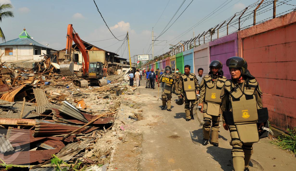 Petugas Satpol PP mengawasi lokasi saat pembongkaran di kawasan Tanah Tinggi, Tangerang, Selasa, (14/3). Sampai saat ini Pemprov kota Tangerang belum menyediakan tempat tinggal untuk warga yang dibongkar rumahnya. (Liputan6.com/Faisal R Syam)