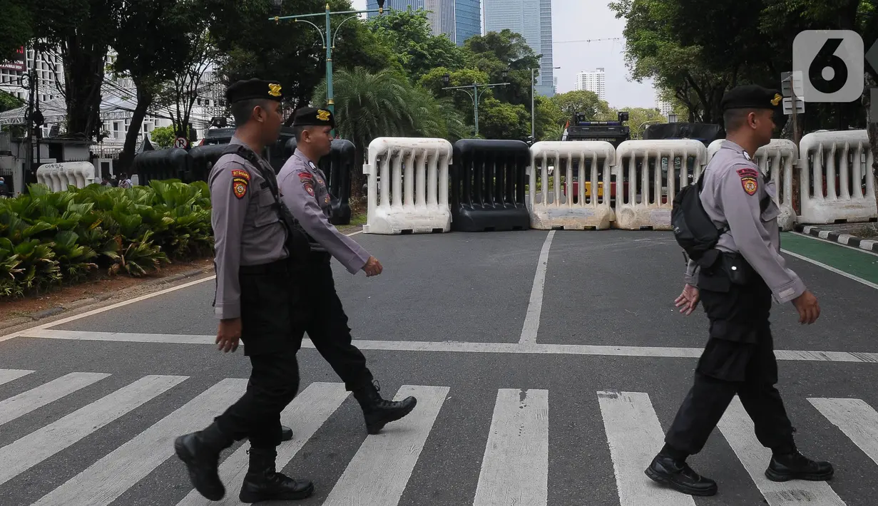 Aparat kepolisian melintas di jalan Imam Bonjol depan Gedung Komisi Pemilihan Umum (KPU) Republik Indonesia, Senin (11/13/2023). (merdeka.com/Imam Buhori)
