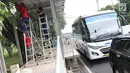 Kendaraan melintasi halte Transjakarta yang sedang dibangun di kawasan Kampung Rambutan, Jakarta, Jumat (1/3). Pembuatan halte tersebut bertujuan mempermudah warga untuk mengakses bus Transjakarta. (Liputan6.com/Immanuel Antonius)