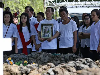 Keluarga dan kerabat korban bom gereja Surabaya berdoa pada pemakaman Martha Djumani di komplek Taman Makam Keputih, Surabaya, Rabu (16/5). Martha merupakan korban bom bunuh diri di Gereja Pantekosta Pusat Surabaya Minggu (13/5) lalu. (AP/Achmad Ibrahim)