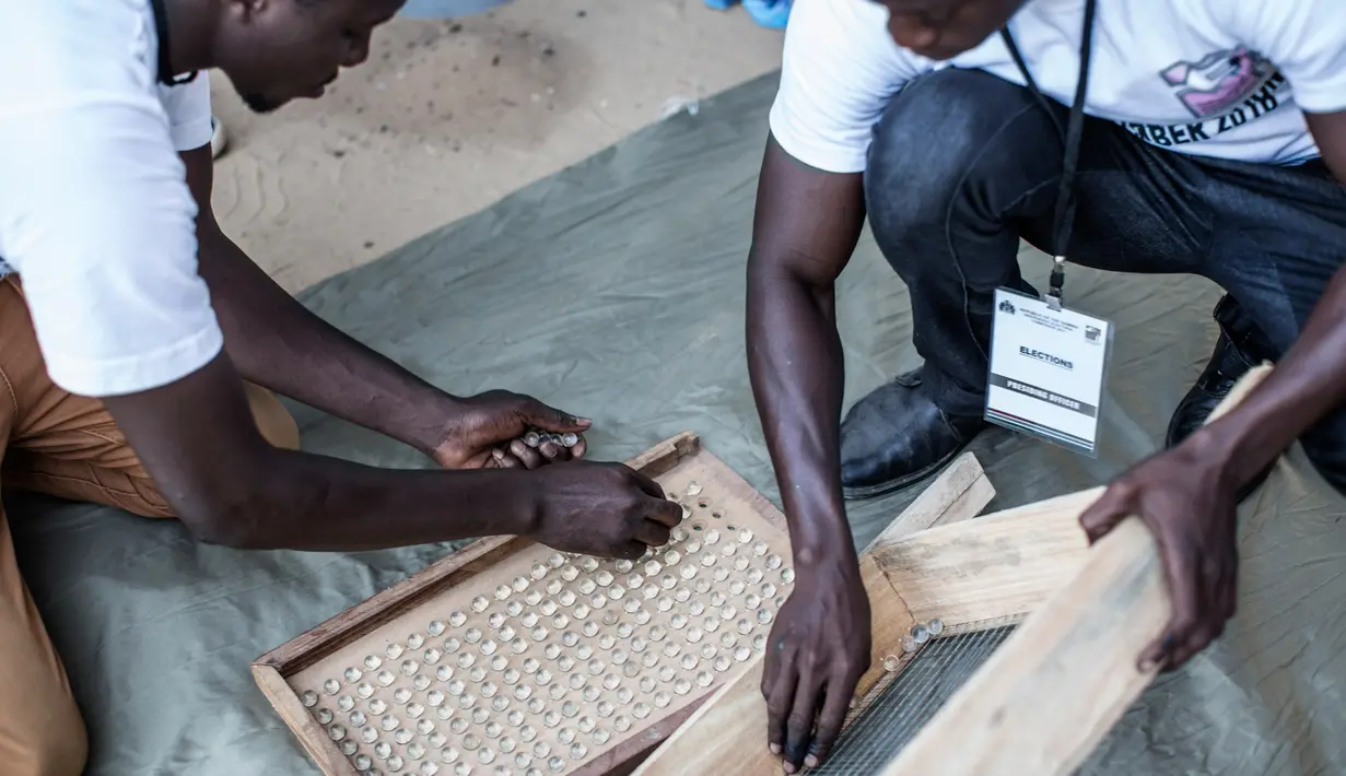 Sejumlah petugas menyiapkan kelereng yang akan digunakan untuk pemilihan Presiden Gambia di distrik Tallinding, Serekunda, Gambia (30/11). Bedanya hanya terdapat pada alat yang digunakan dan cara perhitungan yang unik. (AFP/Marco Longari)