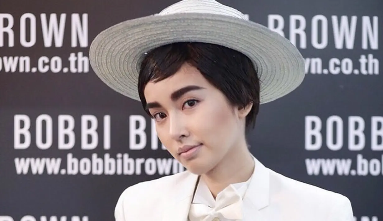 Begini tampilan Nong Poy saat dituntut bergaya ala seorang pria dengan setelan jas putih klasik. [@poydtreechada]