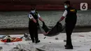 Petugas membawa kantong jenazah korban pesawat Sriwijaya Air SJ-182 yang jatuh di perairan Pulau Seribu, di Dermaga JICT, Jakarta, Selasa (12/1/2021). Pada hari keempat evakuasi ini petugas gabungan menyerahkan kantong-kantong berisikan, bagian tubuh, serpihan pesawat. (Liputan6.com/Johan Tallo)