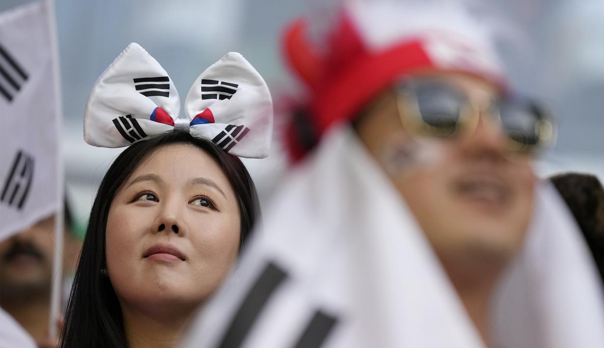 Suporter wanita dengan memakai aksesoris berupa ikat kepala memberikan dukungan kepadaTimnas Korea Selatan dalam pertandingan perdana Grup H Piala Dunia 2022 melawan Timnas Uruguay di Education City Stadium, Qatar, Kamis (24/22/2022). (AP Photo/Alessandra Tarantino)