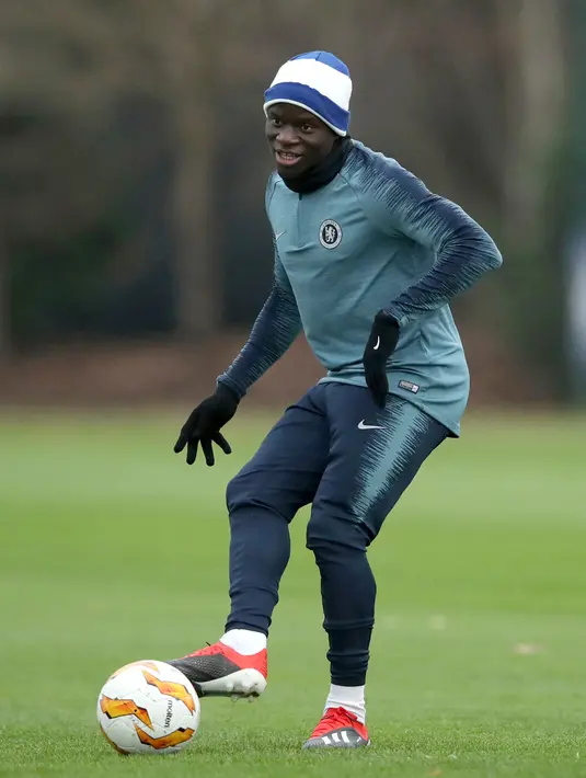 Gelandang Chelsea, N'Golo Kante menendang bola saat mengikuti sesi pelatihan tim di Pusat Pelatihan Cobham, Stoke D'Abernon (28/11). Chelsea akan bertanding melawan PAOK Thessaloniki di grup L Liga Europa di Stamford Bridge. (AP Photo/John Walton)